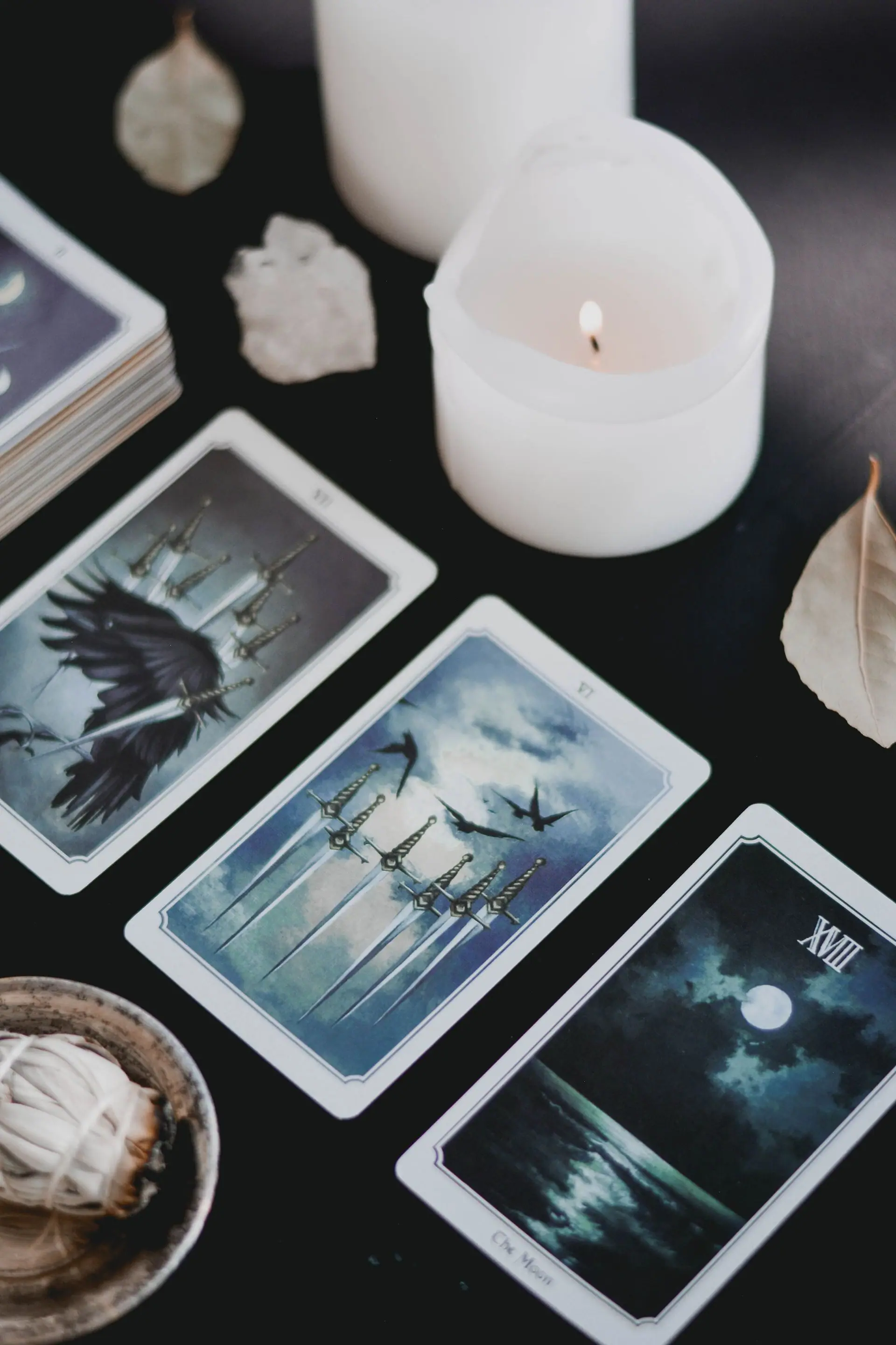 Siyah zeminde tarot kartları ve yanan bir mum